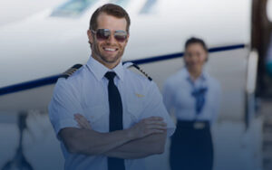 كابتن طيار محترف بابتسامة واثقة يمثل النجاح المهني لخريجي أكاديمية جولف للطيران - Golf Aviation Academy.
